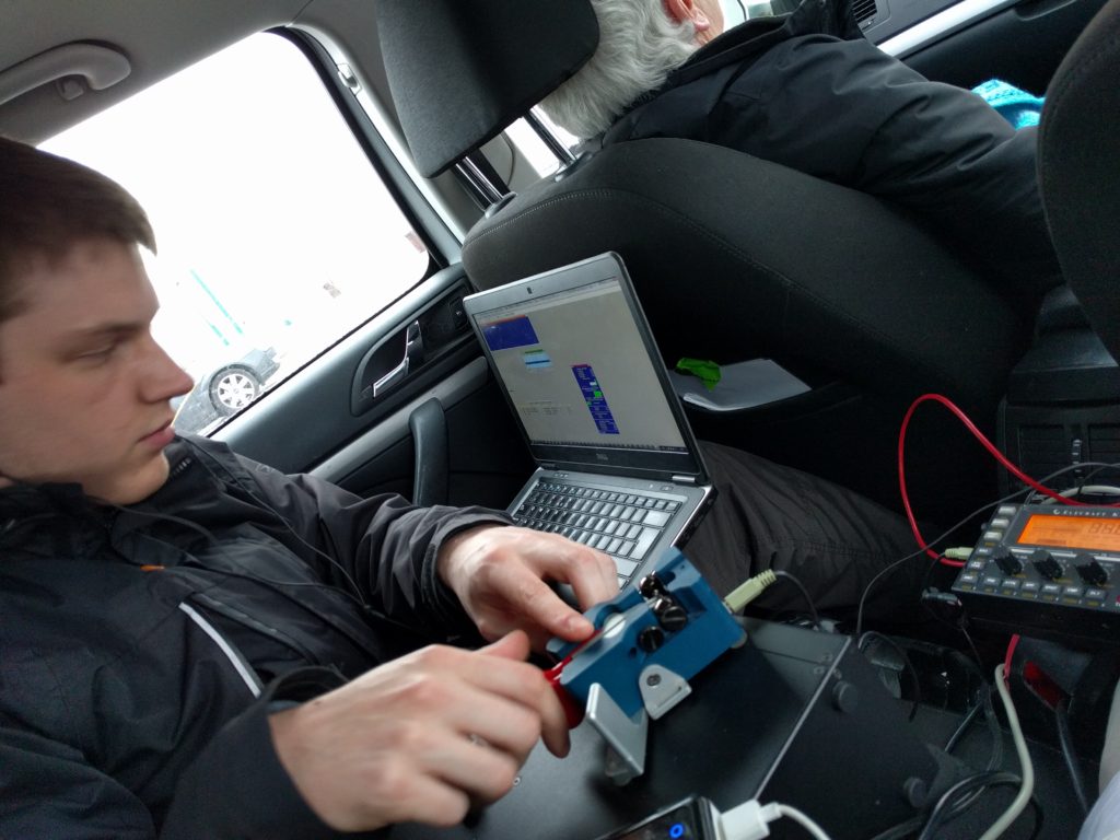 Dan cramped on the back seat of a car with Morse paddle and laptop