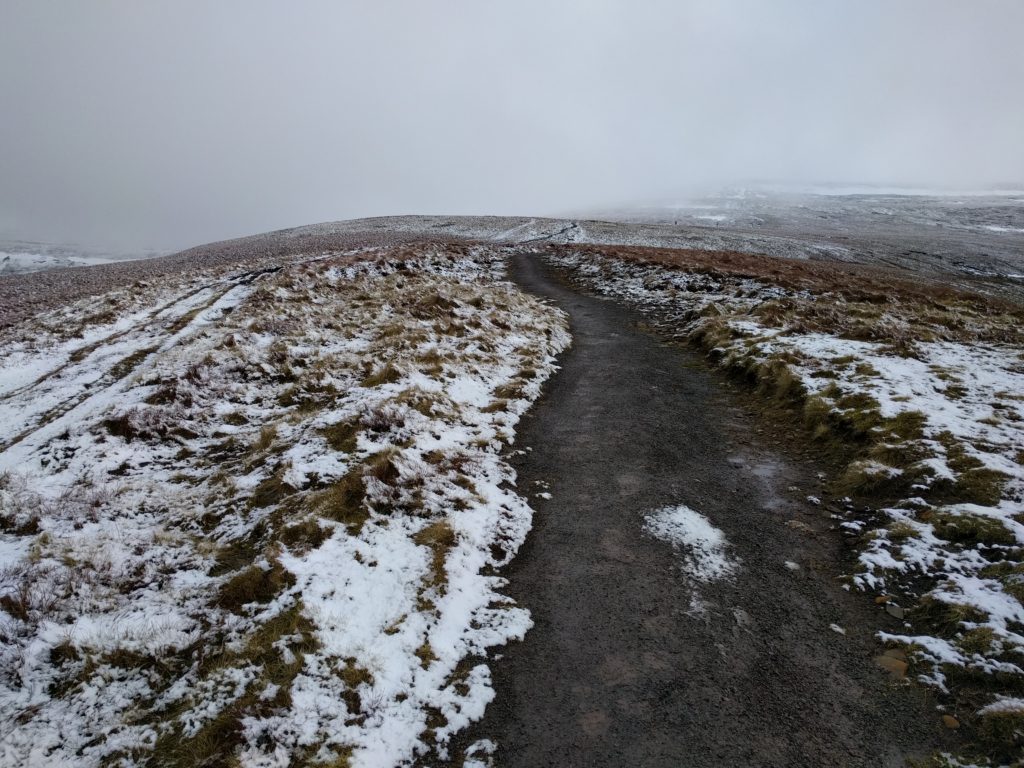 Well made path with some snow on the grass around it