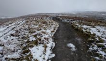 Well made path with some snow on the grass around it