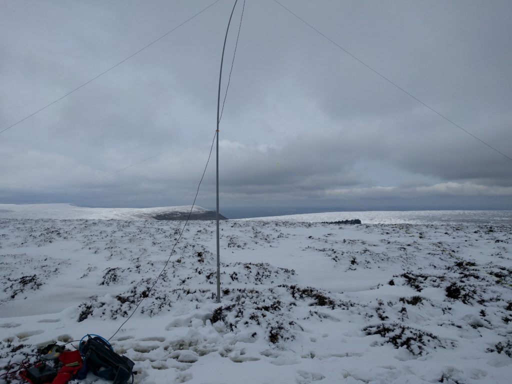 Fibreglass antenna mast standing on snowy ground