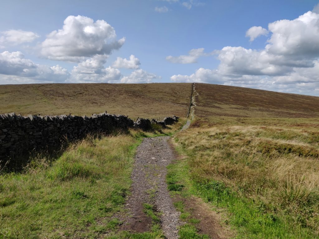 Gravel walking path uphill surrounded by moorland